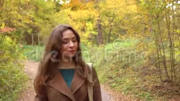 美丽快乐的黑发女孩走过秋天的树林特写4K稳定视频视频的预览图