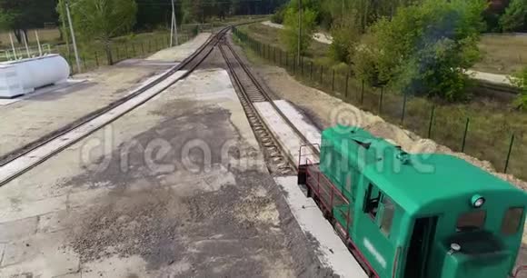 小火车头沿着森林里的铁路行驶绿色火车头沿着森林路空中行驶视频的预览图