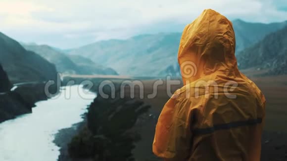 少女雨季看山景女人穿着黄色雨衣希克和视频的预览图