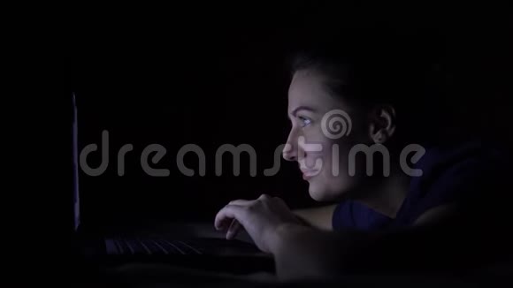 漂亮的年轻女孩晚上躺在家里的床上正在使用手机电脑隔离灯4K视频的预览图