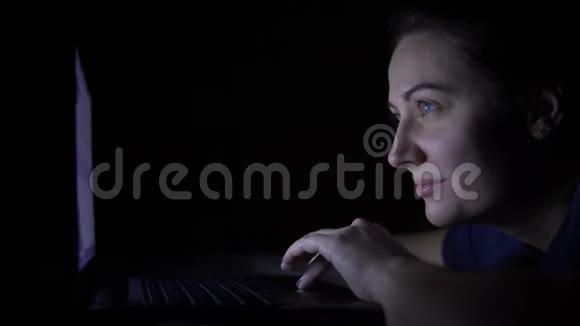 漂亮的年轻女孩晚上躺在家里的床上正在使用手机电脑孤立光视频的预览图