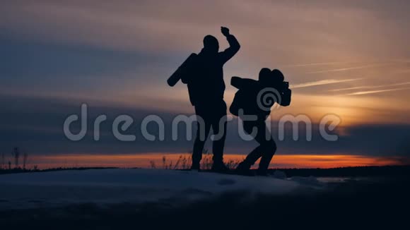 两位游客摄影师剪影的阳光男子自然景观冬雪两名男性摄影师旅行视频的预览图
