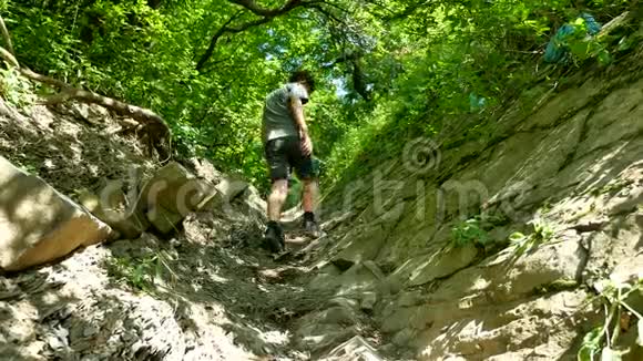 少年沿着小径上升到山上夏天的游客在山林中旅行视频的预览图