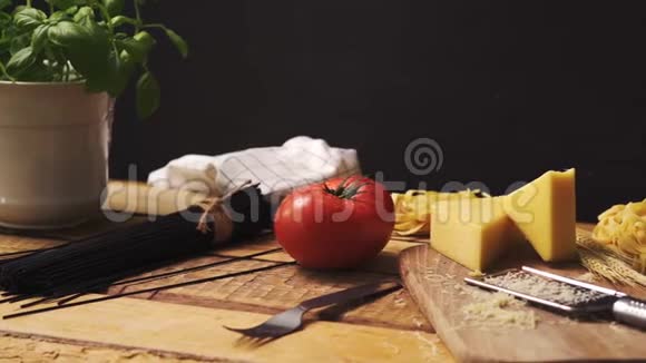 木制厨房桌上有新鲜罗勒和意大利意大利面的碎奶酪视频的预览图