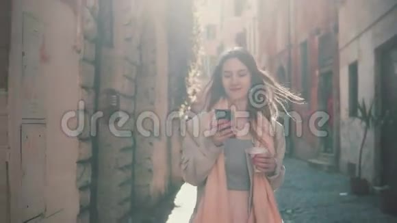 年轻快乐的女人早上在市中心散步用智能手机女孩上网和别人发短信视频的预览图
