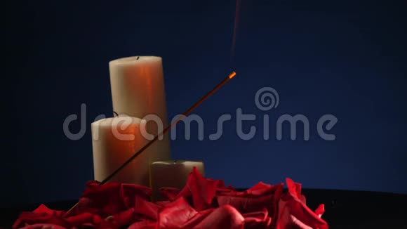 深色背景下有玫瑰花瓣的香枝和蜡烛视频的预览图