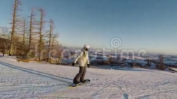 在晴朗的霜天滑雪者正在滑雪场的山坡上滑下来穿滑雪服和头盔的女孩视频的预览图