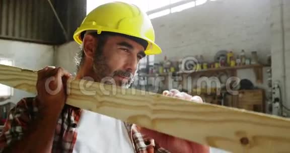 一个木匠扛着一块木头视频的预览图