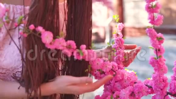 年轻的穿着眼镜的休闲女孩闻着樱花花和微笑进入相机关注脸春概念视频的预览图