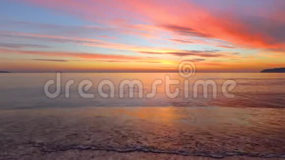海滩上美丽的热带日出海浪冲刷着海湾上的沙子视频的预览图