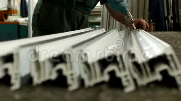 生产pvc窗时工人将金属型材固定在pvc窗段的塑料型材上视频的预览图