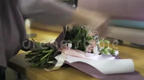 花匠把一束花绑在桌上的丝带上视频的预览图