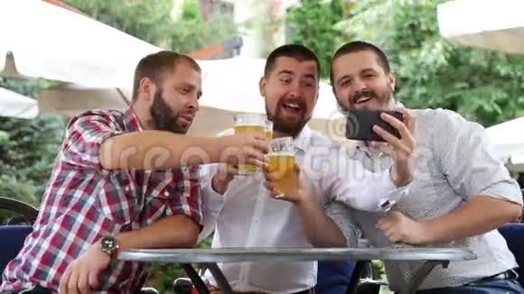 三个人坐在咖啡馆里喝啤酒通过电话拍照视频的预览图