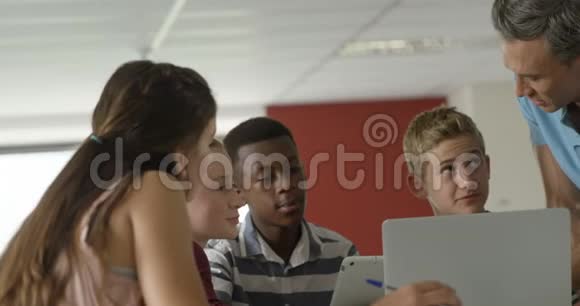 教师协助学童在笔记本电脑4k视频的预览图