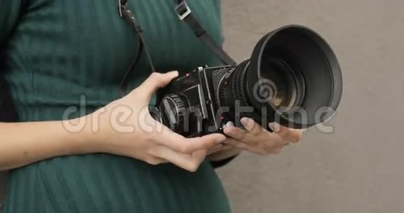 一个时髦女孩手中的老式中型相机特写镜头胶卷相机视频的预览图
