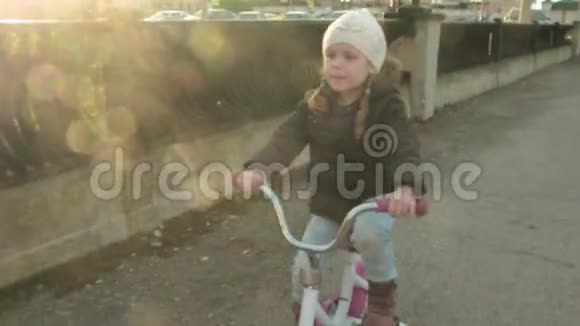 快乐的孩子在户外骑自行车可爱的孩子在户外骑着安全帽骑着红色自行车健康的小女孩视频的预览图