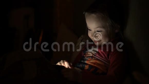 小女孩在黑暗的房间里玩手机游戏视频的预览图
