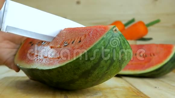 用菜刀将成熟的西瓜切在木切板上再切上新鲜水果供夏季食用视频的预览图