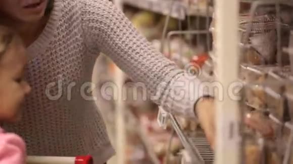 家庭在超市母亲和女儿在杂货店挑选蛋糕视频的预览图