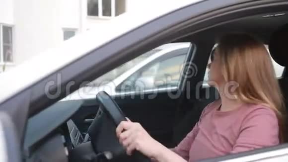 一个年轻的女人坐在停车场倒车视频的预览图
