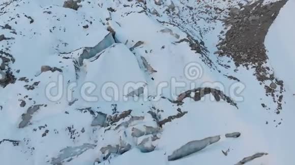 空中观景特写的边缘流动的冰川覆盖着雪和石头高在山上自然破坏视频的预览图