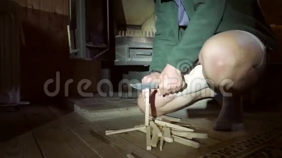 人用刀子在壁炉旁切木棍冬季生活方式高清慢运动视频的预览图