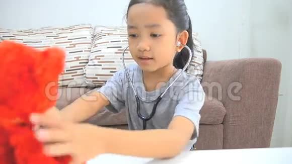 高清特写镜头亚洲小女孩用听诊器扮演医生视频的预览图