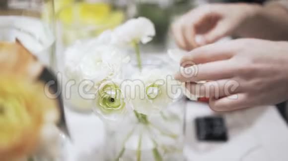 一个女花店把标价贴在花瓶上花瓶上有白色的花视频的预览图