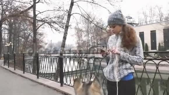 年轻女孩与她的狗一起奔跑的录像阿拉斯加马拉穆特视频的预览图