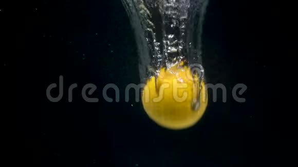 黑色背景下水中柠檬掉落的脚印视频的预览图