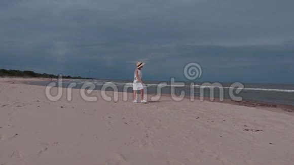 穿着白色裙子的女人走在海边视频的预览图