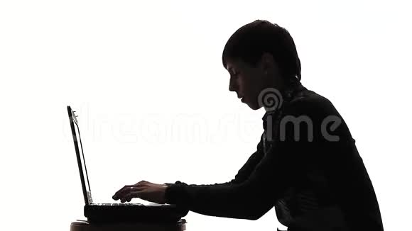 一个人在笔记本电脑后面的剪影视频的预览图