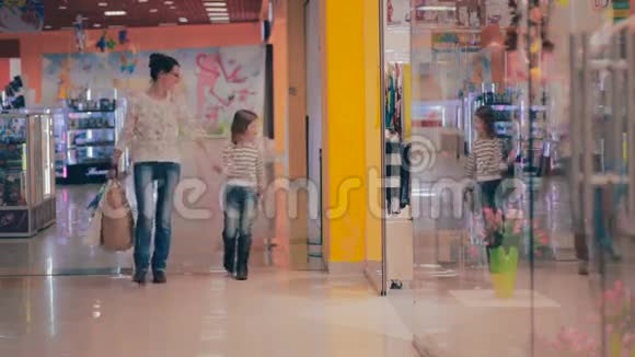 母女俩在购物走在商场里看着购物中心的店面视频的预览图