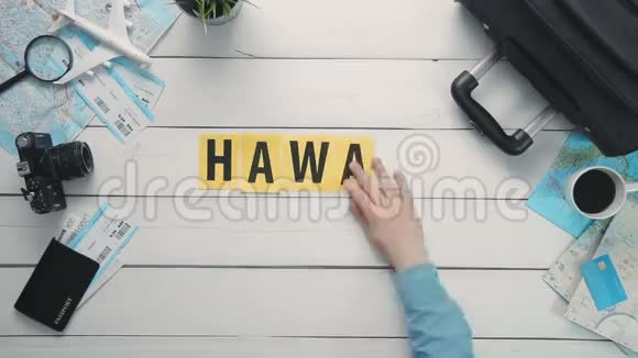 俯视图时间流逝的双手躺在白色桌子上HAWAII装饰着旅行用品视频的预览图