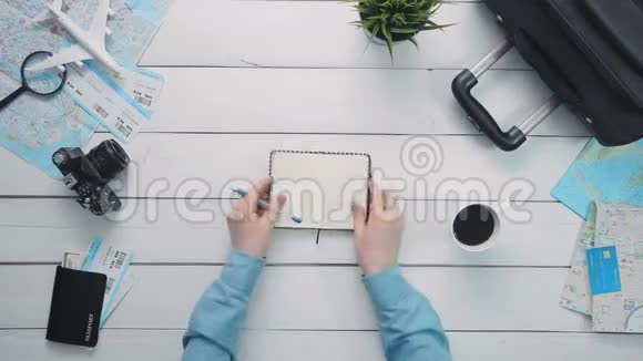 顶景旅客白色木桌上笔记本上的手写笔记视频的预览图
