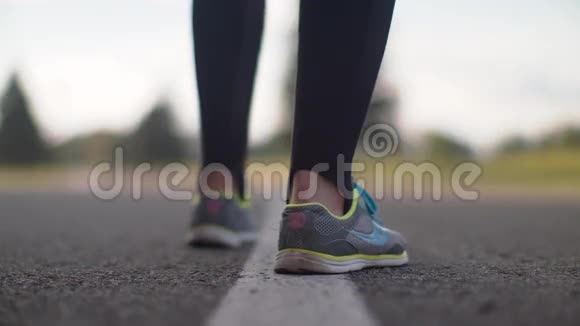 女跑步者的腿开始在路上奔跑穿跑鞋的女人腿特写视频的预览图