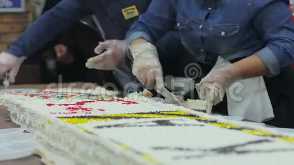 厨师切蛋糕把蛋糕放在盘子里分发免费的饭菜生日购物中心有一个大奶油蛋糕把糖果送给别人视频的预览图