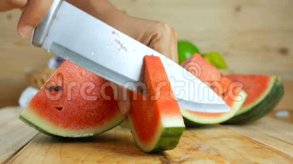 用菜刀将成熟的西瓜切在木切板上再切上新鲜水果供夏季食用视频的预览图