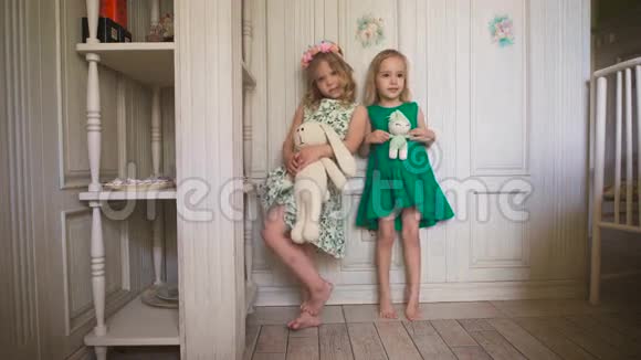 两个快乐的小女孩站在房子里明亮的房间里视频的预览图