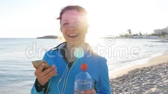 在海滩日落时微笑的女性慢跑者视频的预览图