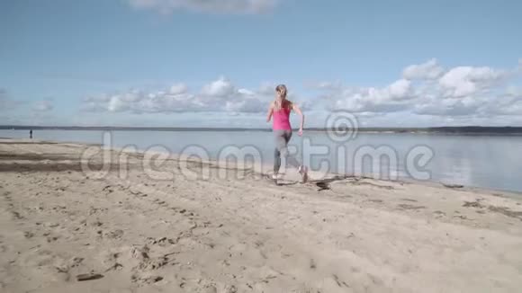 一个阳光明媚的女孩沿着海岸奔跑那个女孩在逃跑视频的预览图