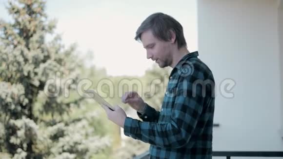 一人在酒店阳台上用电子平板电脑视频的预览图