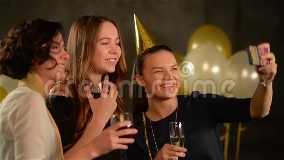 微笑的女孩用数字小玩意在黑色背景的派对上拍摄空气气球青年妇女视频的预览图