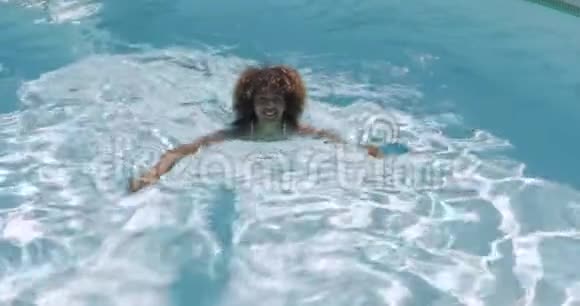 卷曲的女孩在游泳池游泳视频的预览图