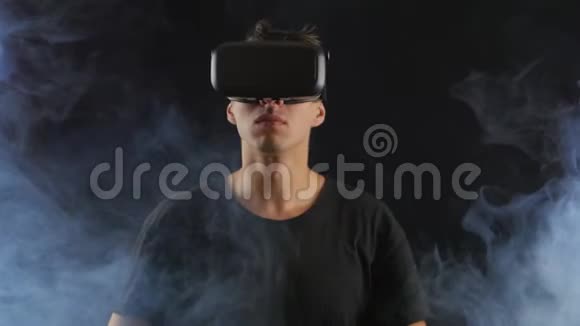 男人用VR头套获得体验站在黑暗中周围有烟雾视频的预览图