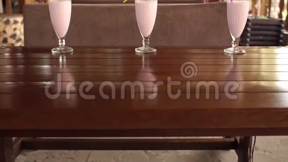 咖啡馆的木桌上摆着三个水果奶昔视频的预览图