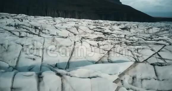 用黑灰近距离俯瞰瓦特纳霍卡尔冰川无人机飞过冰岛的冰山视频的预览图