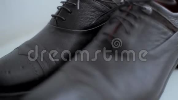 新的黑色皮革男鞋白色背景婚礼日视频的预览图