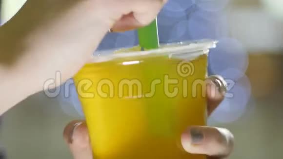 宏人将绿色塑料吸管放入黄色饮料杯中视频的预览图