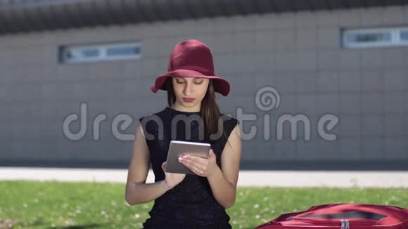 戴红帽的微笑女子在她的写字板上读到了一些东西视频的预览图